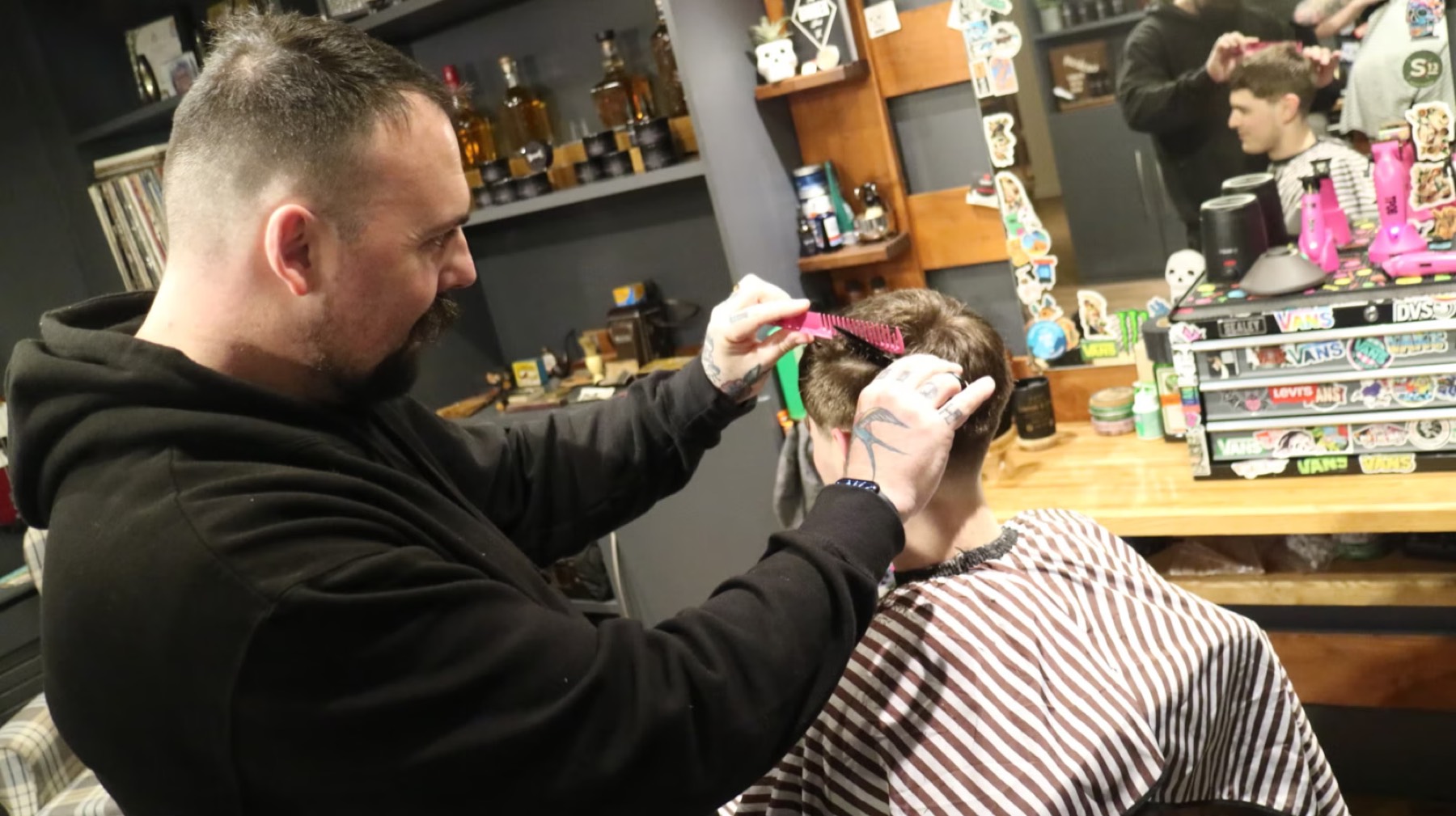 Barber combing and shaping haircut in progress